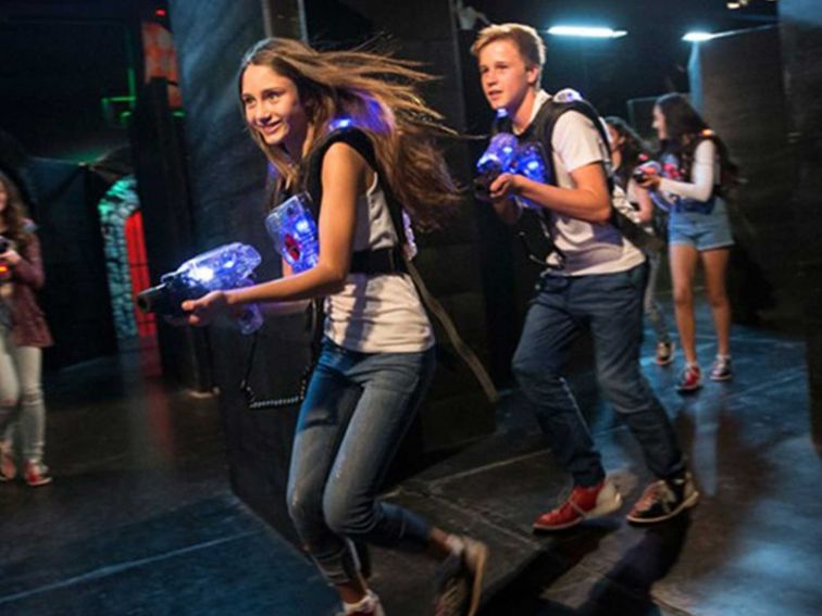 Teens running with Laser tag guns