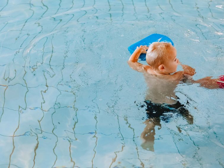 a young boy learning to swim in a pool