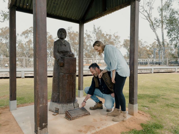 Couple viewing redgum statue