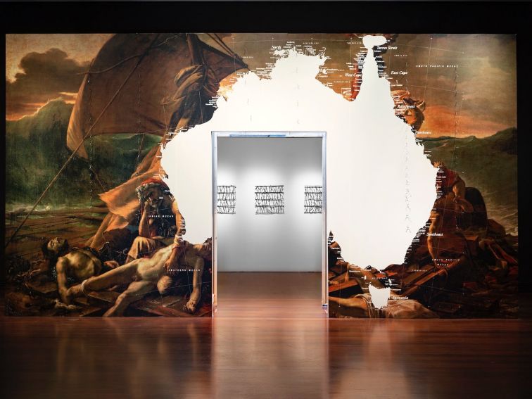 A large wall installation with a door in its centre and an image of the map of Australia