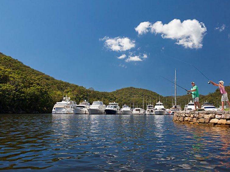 A father and son go fishing next to a marina at Bobbin Head in Ku-ring-gai Chase National Park.