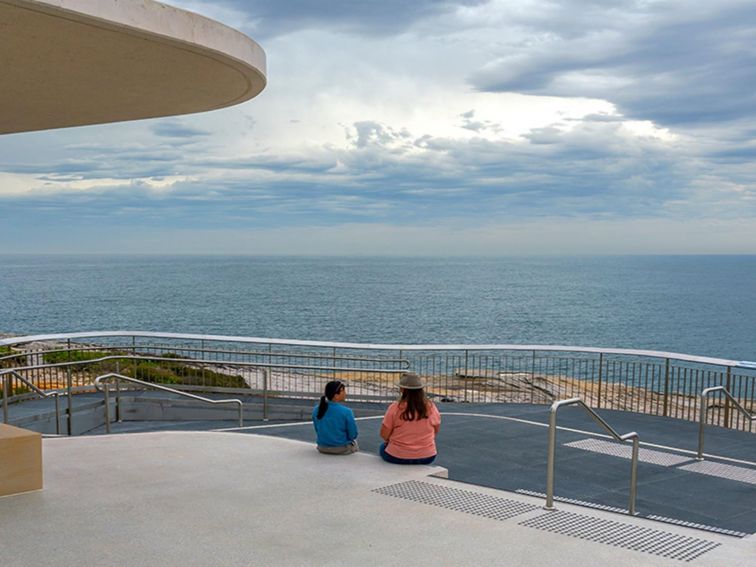 People looking out over the ocean from the whale watching platform at Cape Solander. Photo: John