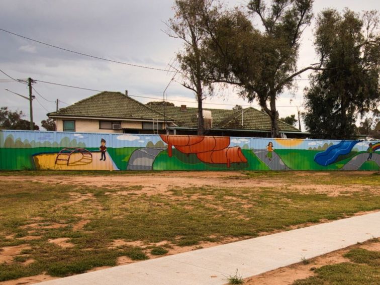 A panel mural featuring young children playing in a plaground.