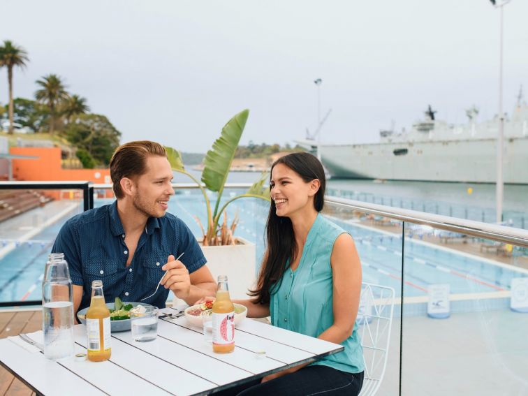 Couple enjoying food and drink at Andrew Boy Charlton Pool, Sydney