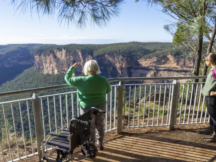 2 visitors taking in the view from Evans lookout in the Blackheath area of Blue Mountains National