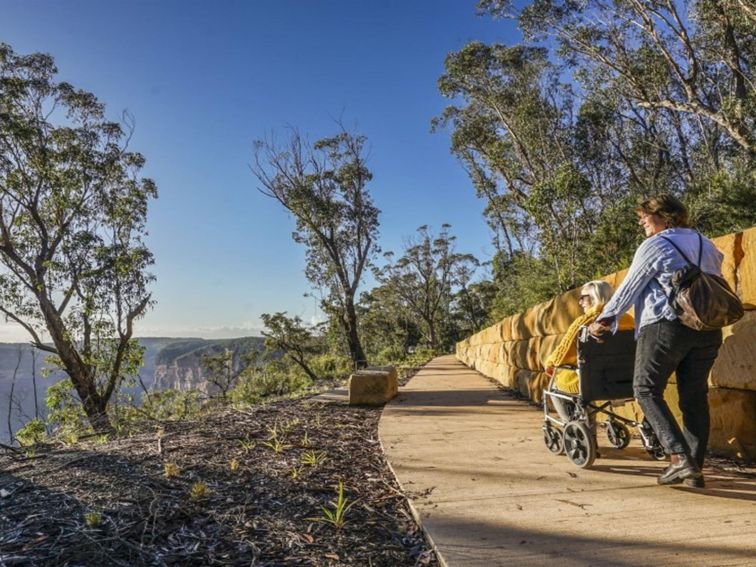 2 visitors along a path at Evans lookout in Blue Mountains National Park. Photo: Simone Cottrell