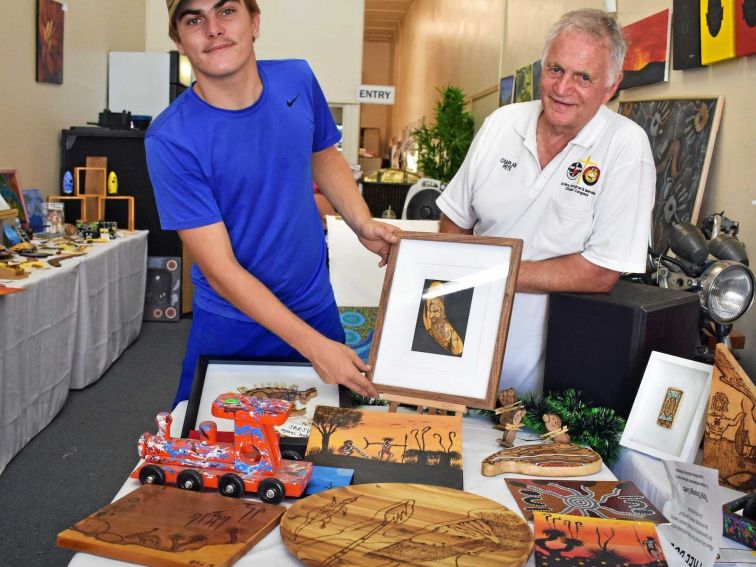 Man and teenage boy displaying local Aboriginal art.