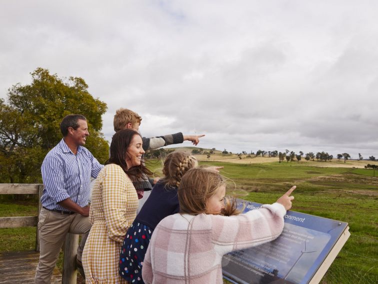 family pointing at wind turbines