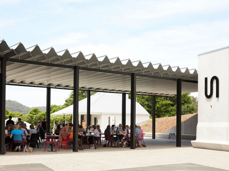 People sitting on tables under a large awning