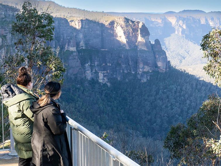 2 visitors at Govetts Leap Lookout among the treetops taking in the view of Grose Valley. Simone
