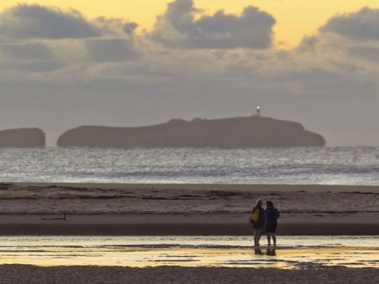 A couple on the shores of Moonee Creek in Moonee Beach Nature Reserve. Photo: Rob Clear &copy; OEH