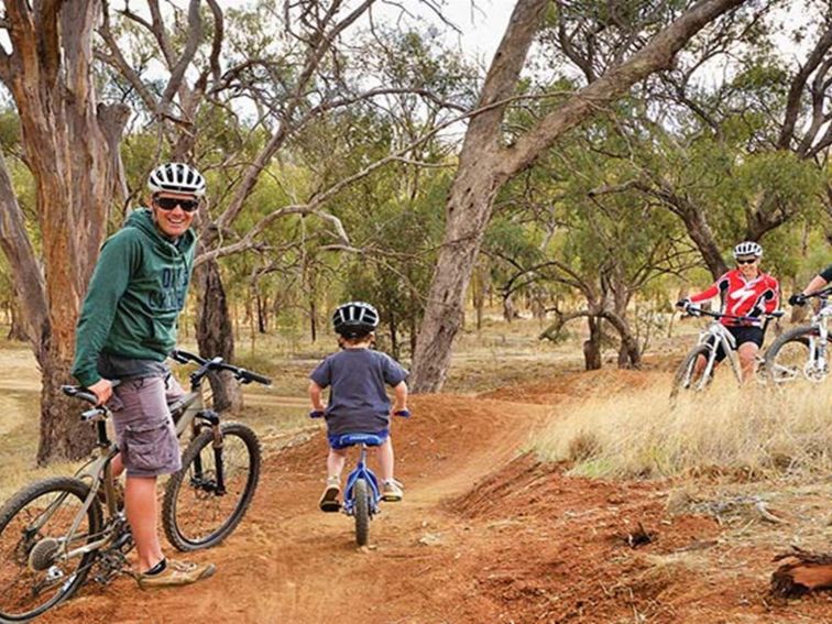 A family riding their bikes at Five Mile mountain bike trail in the Moama area of Murray Valley