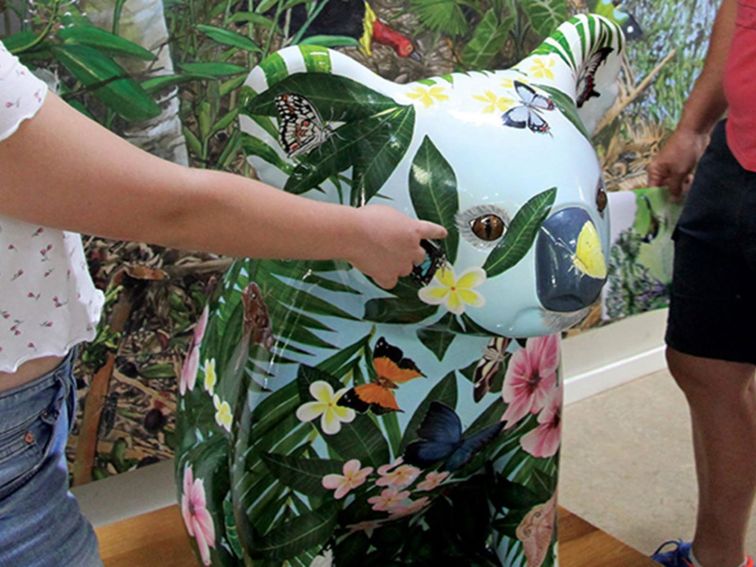 Large koala sculpture painted with flowers and butterflies at Sea Acres Rainforest Centre. Photo: