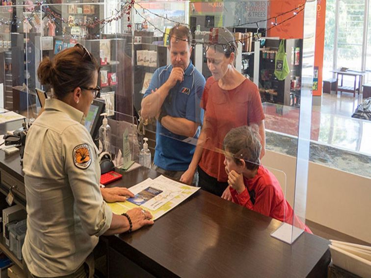 Warrumbungle Visitor Centre staff assist a family with maps and directions. Photo: Leah Pippos