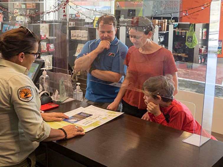 Warrumbungle Visitor Centre staff assist a family with maps and directions. Photo: Leah Pippos