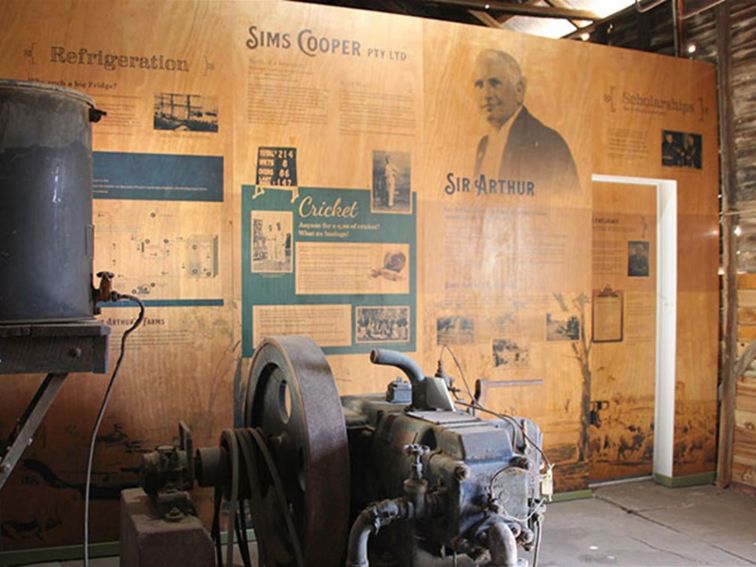 Historic refrigeration machinery with interpretation panels inside a wood shed. Photo: Simone