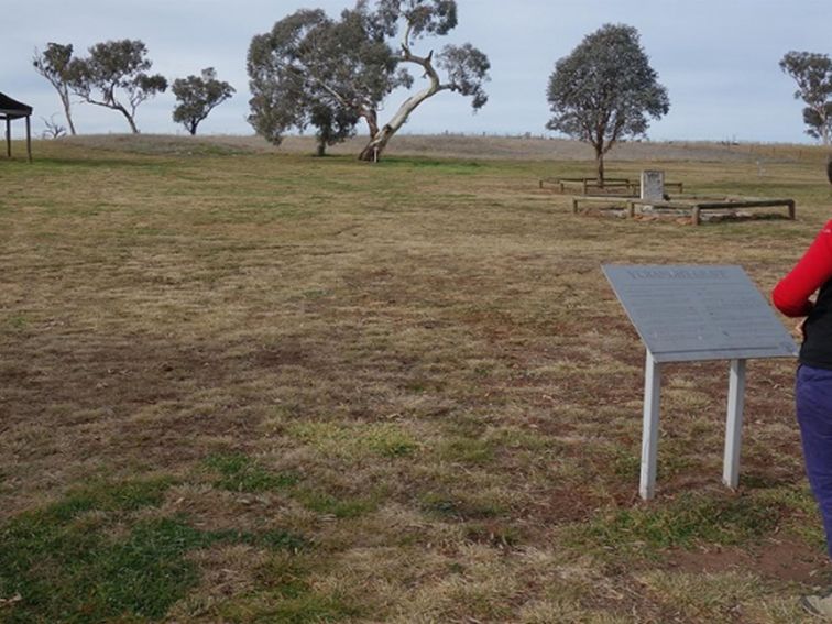 Photo of a visitor reading an interprative sign at Yuranigh's Aboriginal Grave Historic Site. Photo: