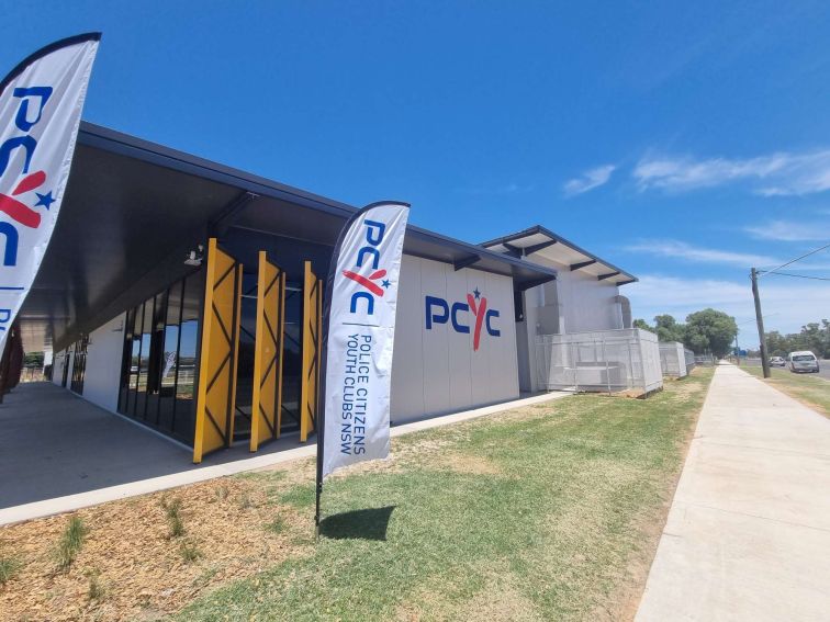 Side of the Walgett PCYC building with flags