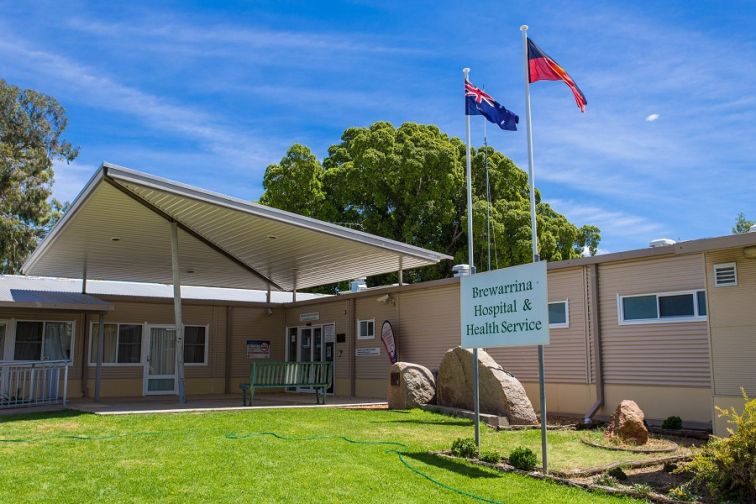 Entry to Brewarrina multipurpose service with green grass and flags