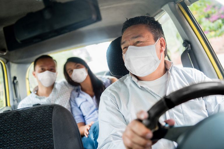 Person wearing a face mask in a car