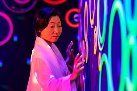 Woman interacting with colourful lighting installation.  Image: Brainbow Magic, Hiromi Tango © Joe Ruckli