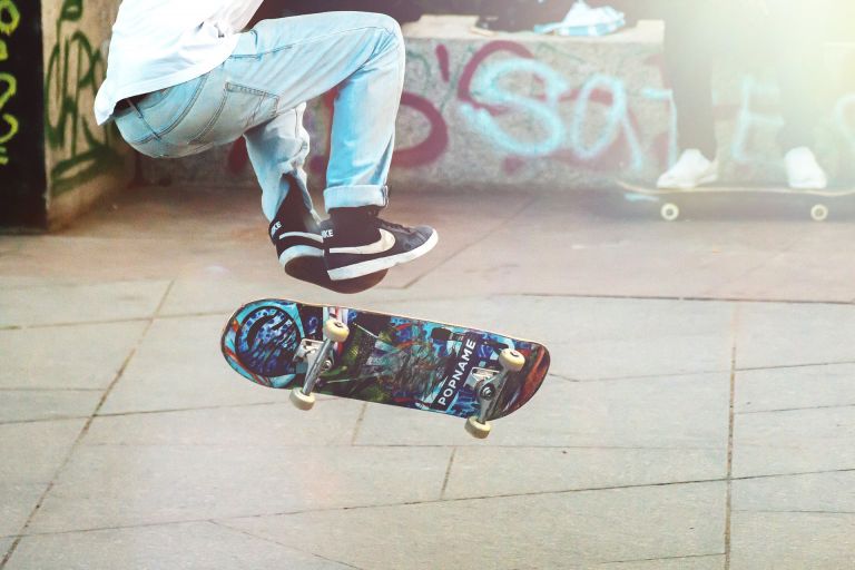 Person from the waist down performing an areal skateboard trick 