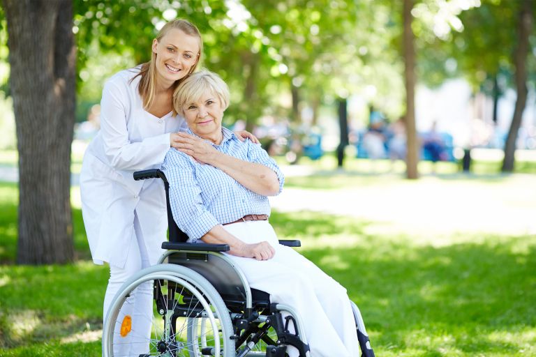 A patient in a wheelchair with their carer