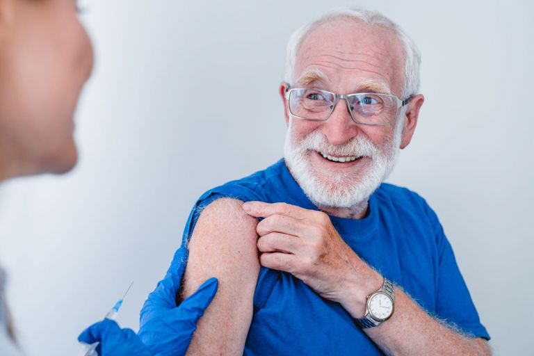 Smiling elderly patient in glasses is getting ready for vaccination