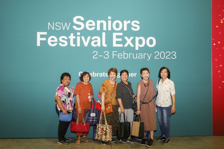 seniors standing infront of seniors festival expo poster