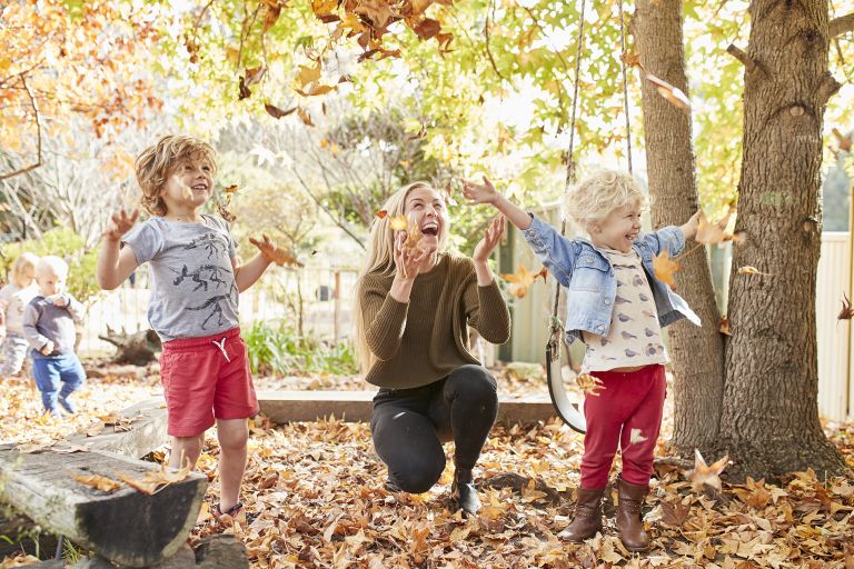Brighter Beginnings parent and children playing with autumn leaves