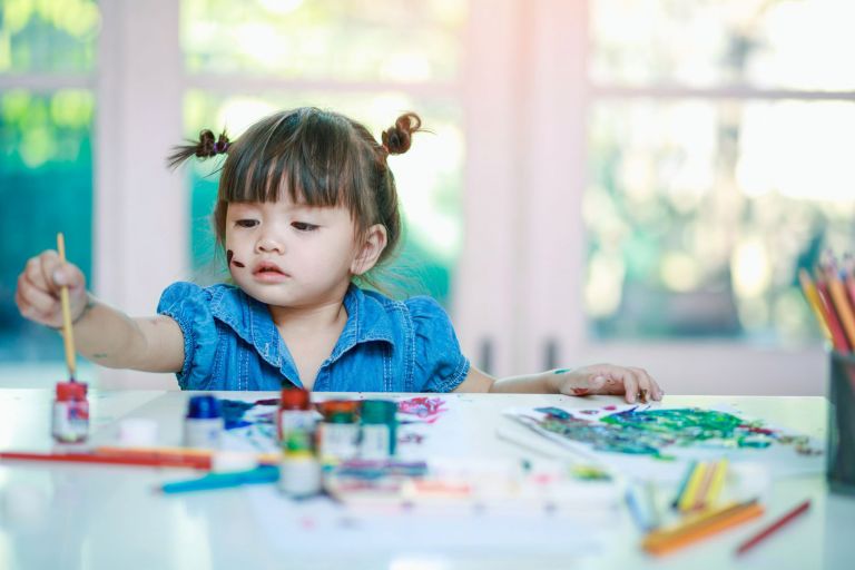 Girl painting in preschool