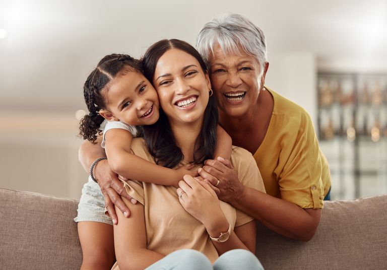 Child, mother and grandmother hugging and smiling