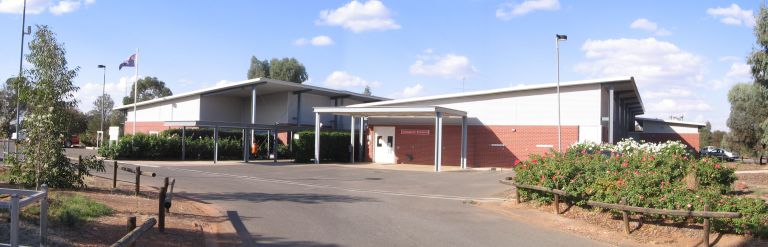 Main entrance access to the West Wyalong Health Service. The driveway runs along the left of the health centre, the ambulance entrance sits within a smaller building to the centre's right, the driveway continues down toward car parking spaces, which is not shown in the image. The main entrance on the right after the ambulance entrance.