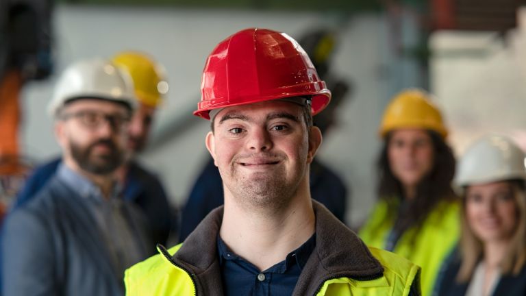 Young man with Down syndrome working in industrial factory