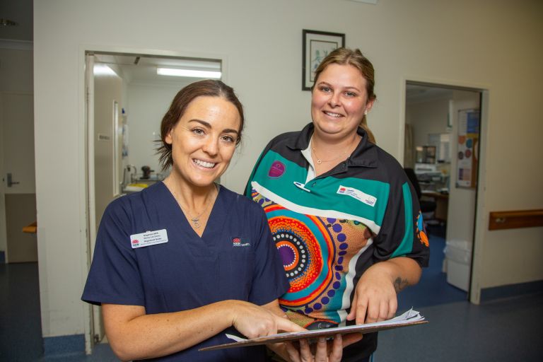 Staff members from Gilgandra MPS smile for the camera while examining a patient's chart.