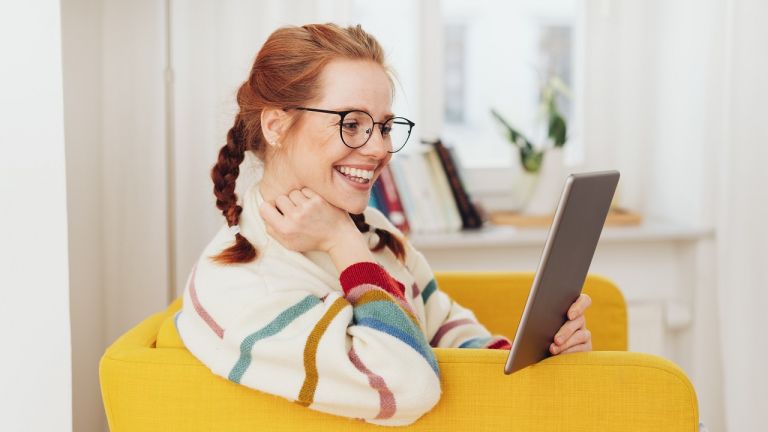 Woman smiling looking at computer tablet
