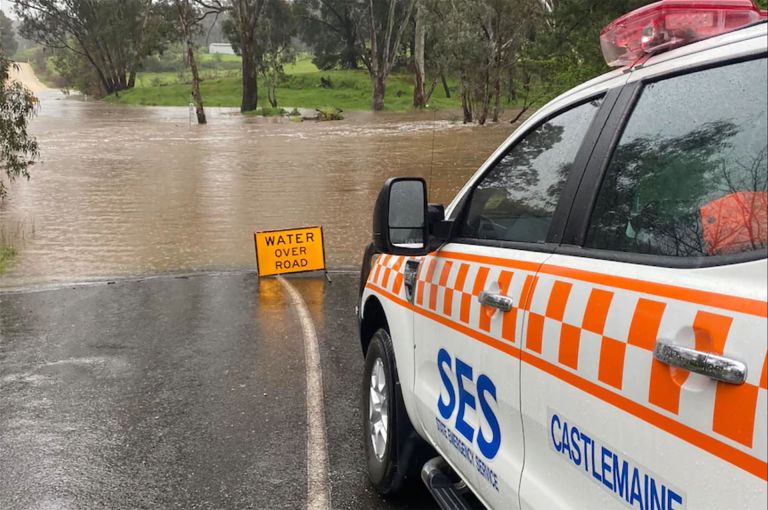 An SES vehicle approaches a flooded road.