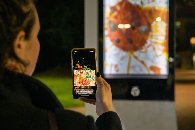 A visitor using a mobile phone while exploring the Newcastle Night Galleries interactive walking trail.