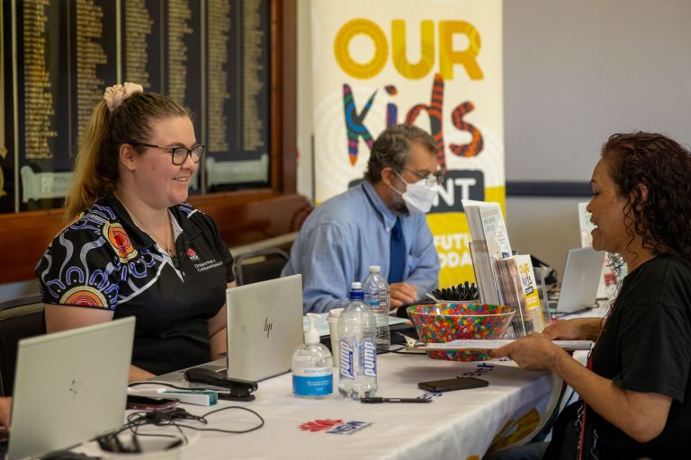 A NSW government employee assists a woman at a birth registration event