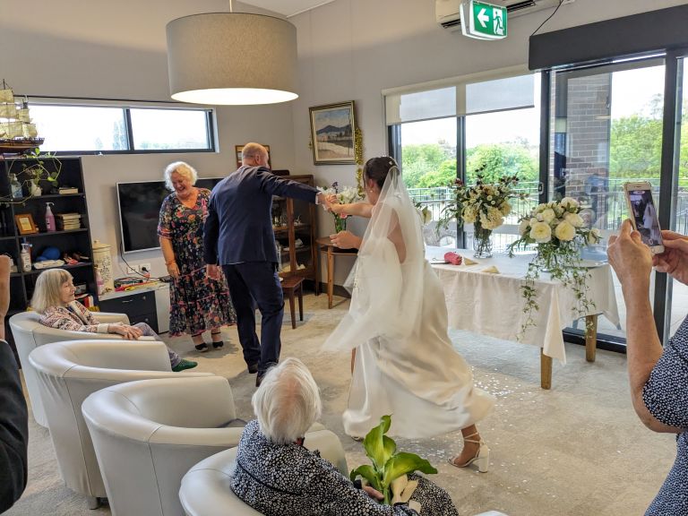 a couple dancing at their wedding with elderly guests
