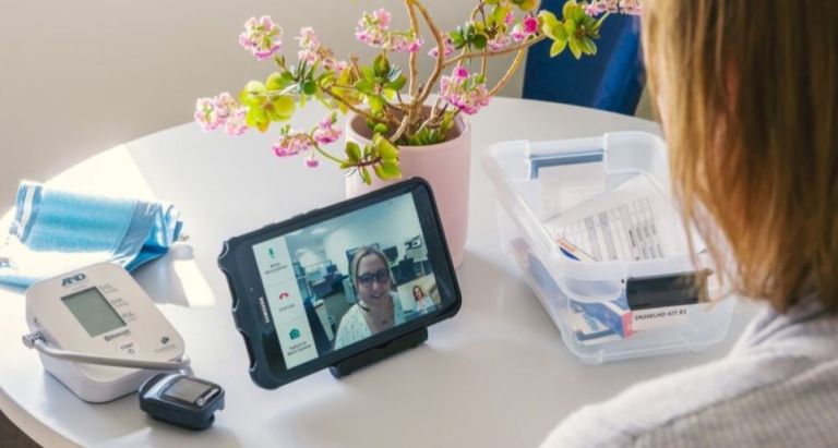 Patient at table using virtual care video conference on device