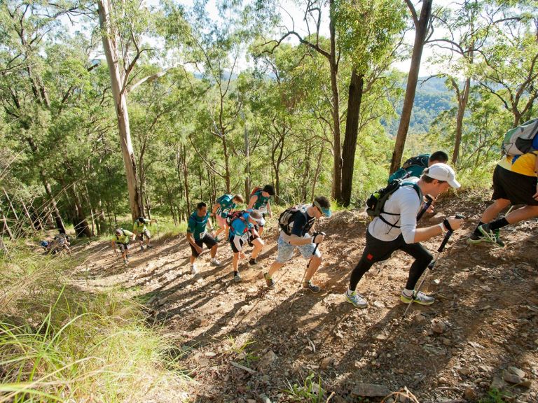 People climbing up steep hill along Kokoda Challenge Hiking track 2022