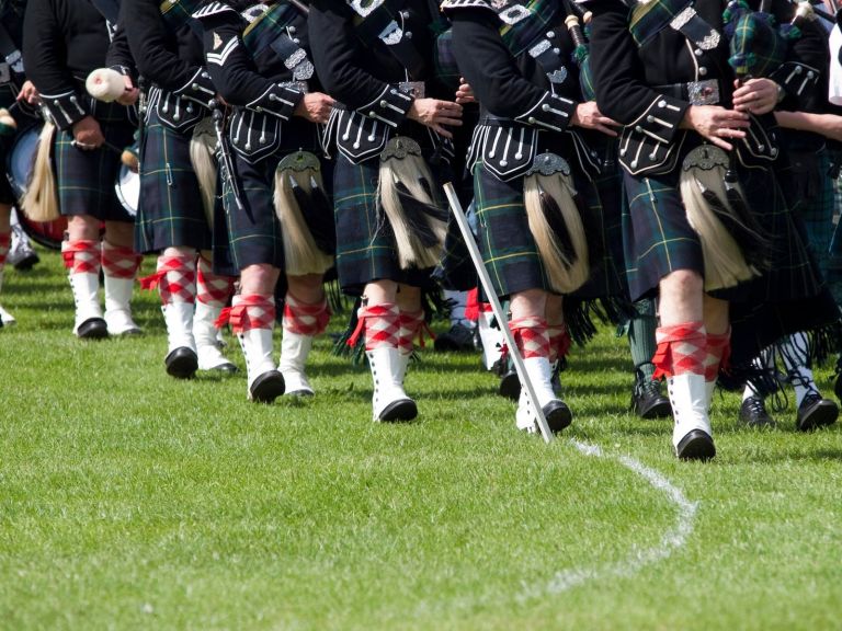 Image of pipers in Scottish dress , marching and playing bagpipes