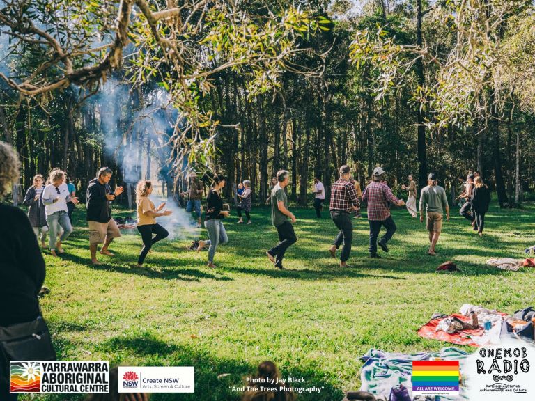 Photo of people dancing round a fire under the trees at Yarrawarra, our happy gathering place