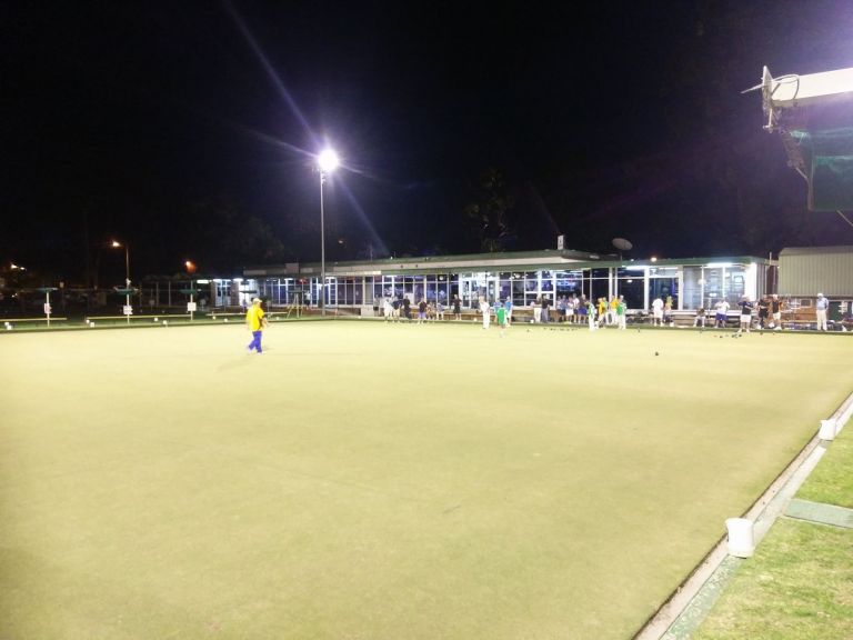 group of people doing lawn bowling at night