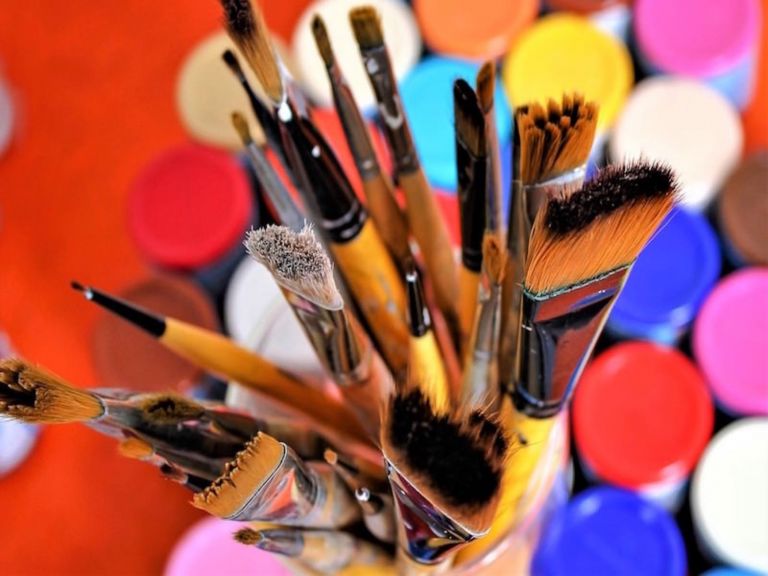 A Bundle of paint brushes in a jar