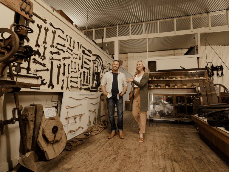 couple exploring old farm utensils at the Federation Museum