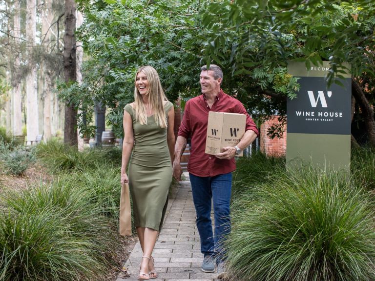 A couple carrying Wine House Hunter Valley wines