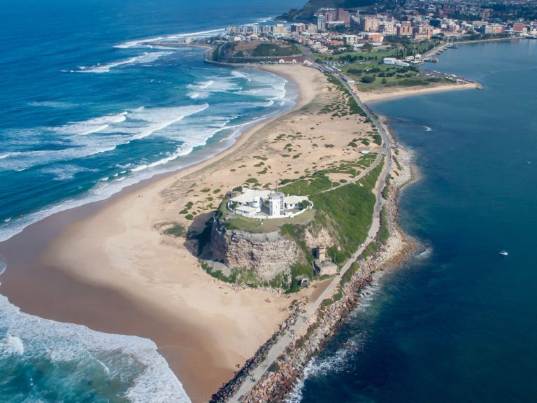 Photo of Newcastle from above Nobbys Lighthouse. View shows beach and edge of the city.