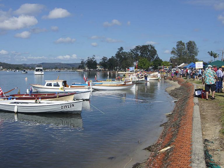 A photo showing boats and festival attendees along the waterside